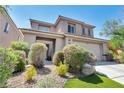 Charming two-story home featuring desert landscaping, mature bushes, and a welcoming entrance at 2449 Daks Loden Ct, Henderson, NV 89044