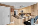Bright kitchen featuring granite countertops, light wood cabinets, and breakfast bar at 270 E Flamingo Rd # 131, Las Vegas, NV 89169