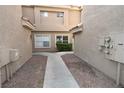 Walkway between buildings with views of stucco walls, and well-kept gravel and landscaping at 5125 W Reno Ave # 1059, Las Vegas, NV 89118