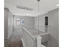 Upstairs hallway features neutral paint, carpet and a railing overlooking the stairwell at 7345 Chesapeake Cove St, Las Vegas, NV 89166