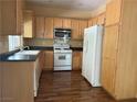Bright kitchen with wood cabinets, laminate floors, and white appliances at 8708 Gateway Glen Dr, Las Vegas, NV 89178