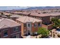 Drone shot capturing the house in a neighborhood with desert landscaping and mountain views in the background at 9032 Retro Ct, Las Vegas, NV 89149