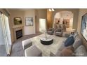 Bright living room featuring a cozy fireplace, plush seating, and open access to the kitchen at 10321 Birch Bluff Ln, Las Vegas, NV 89145