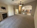 Open-concept living area with fireplace, ceiling fan, neutral color palette, and seamless flow to the kitchen at 10321 Birch Bluff Ln, Las Vegas, NV 89145