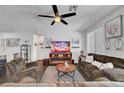 Comfortable living room featuring an electric fireplace, tile floors, a ceiling fan, and ample seating at 1120 Via Della Curia, Henderson, NV 89011