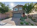 Lovely two-story home boasting lush landscaping, a paved driveway, and a convenient two-car garage at 1266 Smokey Valley Ln, Henderson, NV 89002