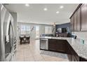 Open-concept kitchen featuring stainless steel appliances, granite countertops, and backyard access at 1266 Smokey Valley Ln, Henderson, NV 89002