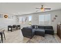 Bright living room with a large sectional sofa, tile flooring, and view to backyard at 1266 Smokey Valley Ln, Henderson, NV 89002
