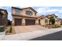 Charming two-story stucco home features a three-car garage and paved driveway at 2575 Hazelburn Ave, Henderson, NV 89044