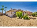 Tan home with stone accents and desert landscaping including drought-resistant rock and green shrubbery at 2851 Winchester Ave, Pahrump, NV 89048