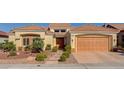 Inviting front exterior featuring a well-manicured landscape, tile roof, and attached two-car garage at 3032 Highland Falls Dr, Las Vegas, NV 89134