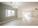 Bright, open-concept living room with tile floors, natural light, and a chandelier at 3312 Speckle Summer Pl # 3, North Las Vegas, NV 89084
