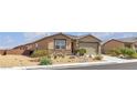 Single story home with tan stucco, a stone accent wall, and desert landscaping at 3964 E Marathon Dr, Pahrump, NV 89061
