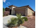 Welcoming single-story home with a two-car garage and attractive desert landscaping in the front yard at 5235 E La Campana Dr, Pahrump, NV 89061