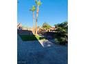 Expansive backyard with artificial grass, palm trees, and a paved patio at 5568 Yellow Ash St, Las Vegas, NV 89118