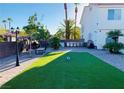 Manicured backyard featuring a lush lawn, outdoor kitchen, and barbecue area at 5568 Yellow Ash St, Las Vegas, NV 89118