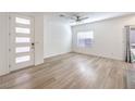 Bright living room with light wood floors, ceiling fan, a large window, and a front door with frosted windows at 600 N Carriage Hill Dr # 1143, Las Vegas, NV 89138