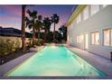 Stunning backyard pool with spa, surrounded by lush landscaping and palm trees, perfect for outdoor entertaining at 605 Canyon Greens Drive Dr, Las Vegas, NV 89144