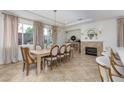 Dining room with large windows and drapery, modern chandelier, and fireplace at 7126 Mirkwood Ave, Las Vegas, NV 89178