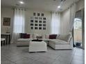 Bright living room featuring a large sectional sofa, tiled floors, and modern decor at 782 Omaggio Pl, Henderson, NV 89011