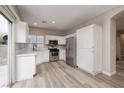 Well-lit kitchen with white cabinets, stainless steel appliances, and access to the backyard at 7836 Pinnochio Ave, Las Vegas, NV 89131