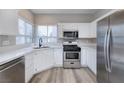 Modern kitchen features white cabinets, stainless steel appliances, quartz countertops and a window at 7836 Pinnochio Ave, Las Vegas, NV 89131