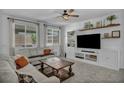 Bright living room featuring modern furniture, a ceiling fan, and abundant natural light through large windows at 8055 Tank Loop St, Las Vegas, NV 89166