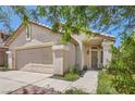 Close up of the exterior, showcasing the front door, a two car garage, and a landscaped yard at 8242 Tribute Ln, Las Vegas, NV 89147