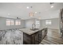 Open concept kitchen with granite countertops, dark wood cabinets, and stainless steel sink at 8754 Moon Crater Ave, Las Vegas, NV 89178