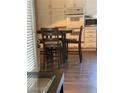 Kitchen with white cabinets, dining table and black chairs, and dark floors at 9036 Cotton Rose Way, Las Vegas, NV 89134