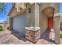 Home exterior showing the stone-accented garage with a brick-paved driveway and entryway at 9208 S Park St, Las Vegas, NV 89178