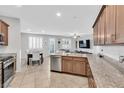 Modern kitchen featuring stainless steel appliances, granite countertops, a breakfast bar, and an open view to the living area at 9208 S Park St, Las Vegas, NV 89178
