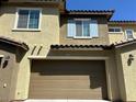 Attached two-car garage with a brown door complementing the home's exterior at 965 Nevada State Dr # 39102, Henderson, NV 89002