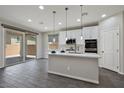 Kitchen island with a sink, pendant lights, and sliding glass doors to the patio at 10270 Turkish Pine Ct, Las Vegas, NV 89166