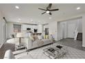 Spacious living room with a view of the modern kitchen and staircase at 10270 Turkish Pine Ct, Las Vegas, NV 89166
