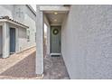A welcoming entryway featuring a green front door adorned with a wreath and stone walkway at 10292 Fragrant Apple Ct, Las Vegas, NV 89141