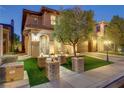 Charming two-story home with manicured front yard and decorative brick features, illuminated by elegant outdoor lighting at 1272 Olivia Pkwy, Henderson, NV 89011