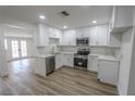 Renovated kitchen with white cabinets, stainless steel appliances, wood-look flooring, and plenty of natural light at 1413 Culley St, Las Vegas, NV 89110
