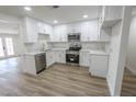 Beautiful kitchen with white cabinets, stainless steel appliances and wood-look flooring at 1413 Culley St, Las Vegas, NV 89110
