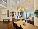 Open-concept living space with a cozy fireplace, hardwood floors, and a view of the staircase at 1704 Cordoba Canyon St, Las Vegas, NV 89117