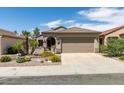 Inviting single-story home features a two-car garage, desert landscaping, and a well-maintained lawn for enhanced curb appeal at 2120 Desert Woods Dr, Henderson, NV 89012