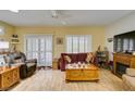 Warm and inviting living room featuring wood laminate flooring, a cozy fireplace, and plentiful natural light at 2120 Desert Woods Dr, Henderson, NV 89012