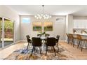 Contemporary dining room boasts modern light fixture, stylish decor and sliding door access to outdoor space at 2227 Garden City Ave, Henderson, NV 89052