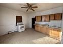 Kitchen featuring tile floors, ceiling fan, white oven, wooden cabinets, and a sink at 26 Avenue B, McGill, NV 89318