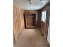 A room featuring wood paneled walls, window with trim, worn wood floor, and built in wardrobe at 26 Avenue B, McGill, NV 89318