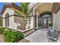 Charming front entryway with stone accents, decorative plants, and an outdoor seating area at 5855 Boulder Brook Ct, Las Vegas, NV 89149