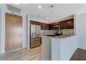 Contemporary kitchen with stainless steel refrigerator, dark wood cabinets, and granite countertops at 8255 S Las Vegas Blvd # 1816, Las Vegas, NV 89123