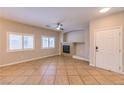 Bright living room with tiled floors, large windows, a fireplace, and neutral walls at 8775 Traveling Breeze Ave # 102, Las Vegas, NV 89178