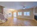 Open living area with tile flooring, a cozy fireplace, and staircase to the upper level at 8775 Traveling Breeze Ave # 102, Las Vegas, NV 89178