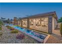 Stunning backyard featuring a long pool, beautiful landscaping, and a covered patio with large windows offering seamless indoor-outdoor living at 9 Rue Grimaldi Way, Henderson, NV 89011